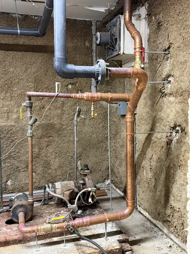 Large-diameter copper piping run through a mechanical room